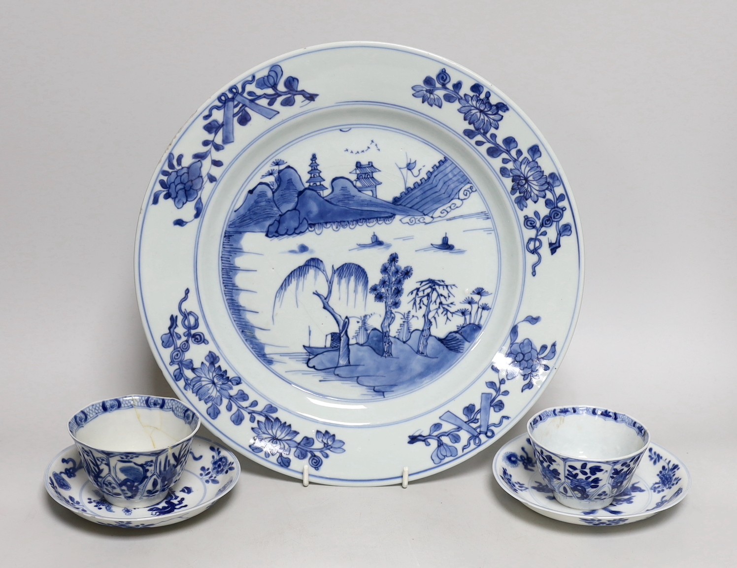 A Chinese blue and white landscape dish, Qianlong period 31cm diameter, together with a similar pair of tea bowls and saucers